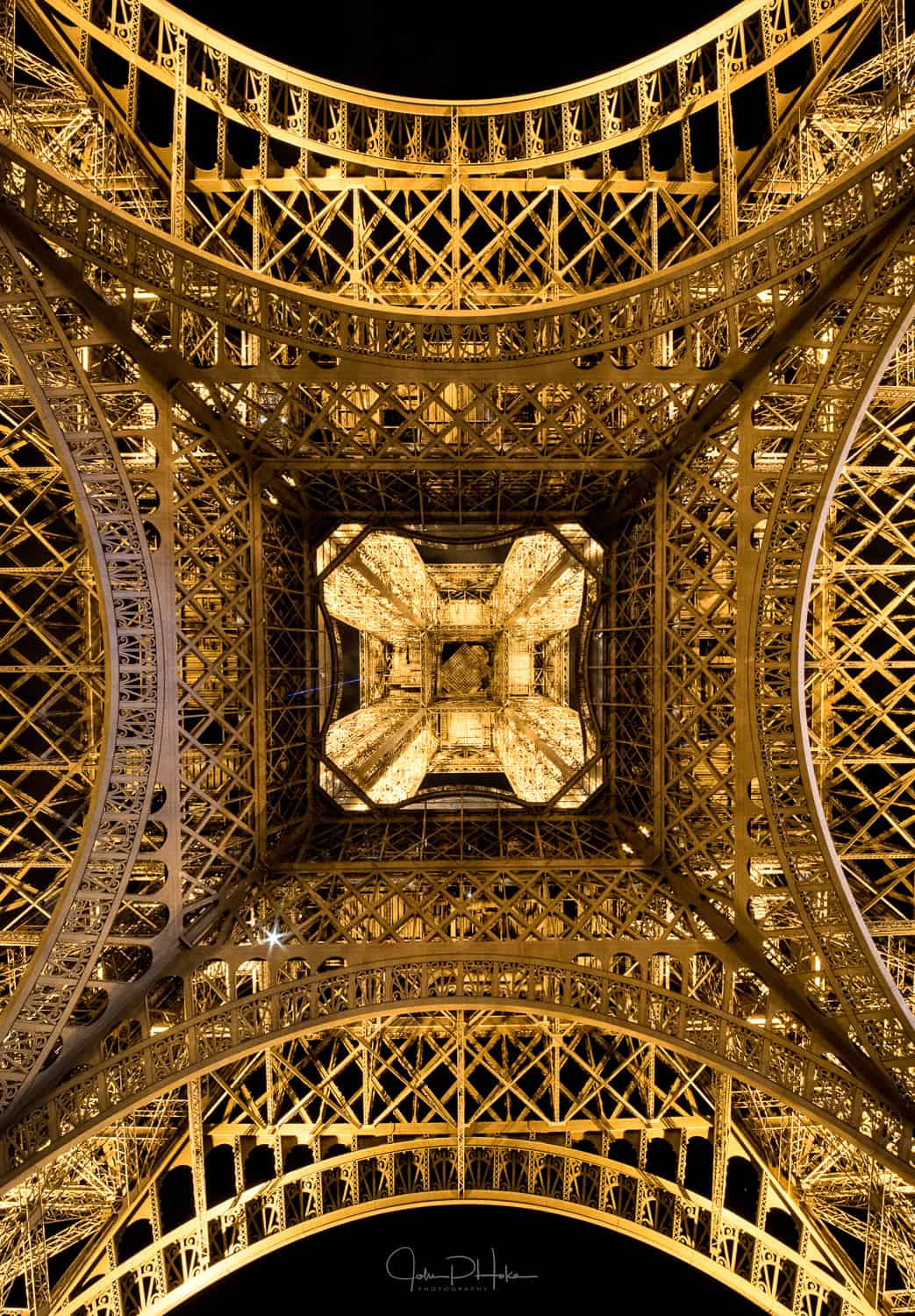 Looking up through the Eiffel Tower at night. Paris, France