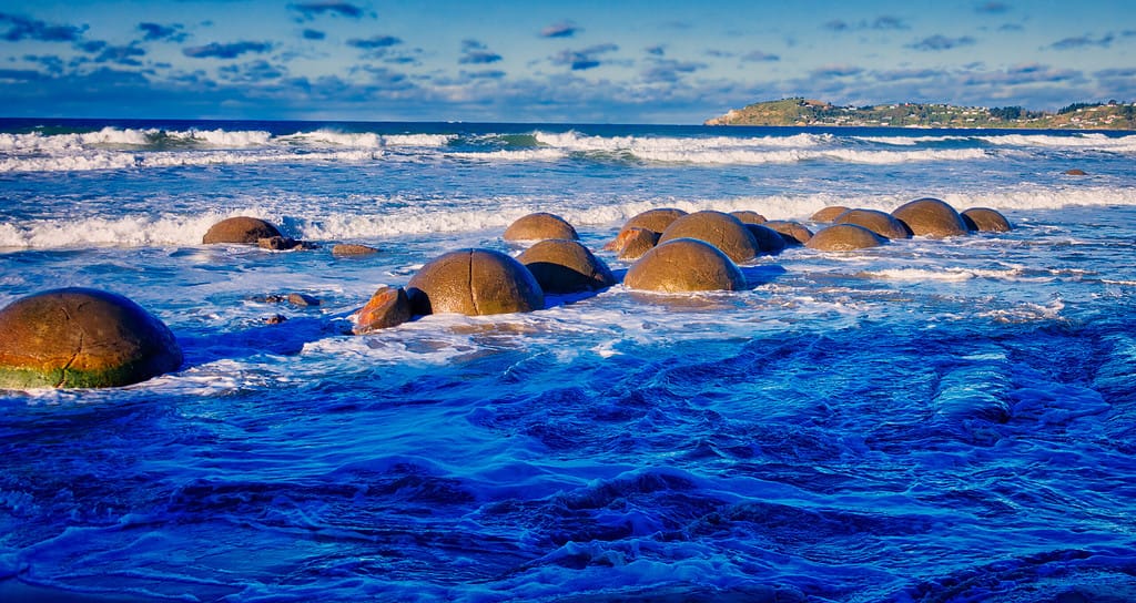 A group of Moeraki Boulders in the waves
