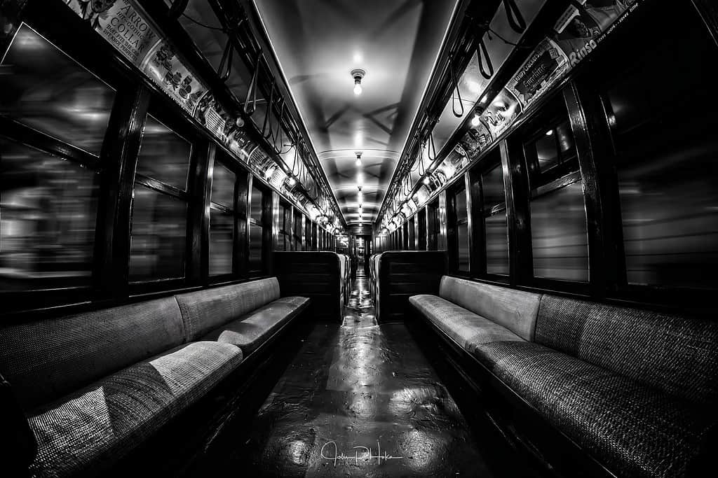 Black and white image of a vintage subway car appearing to move through tunnels at speed. HDR Photo