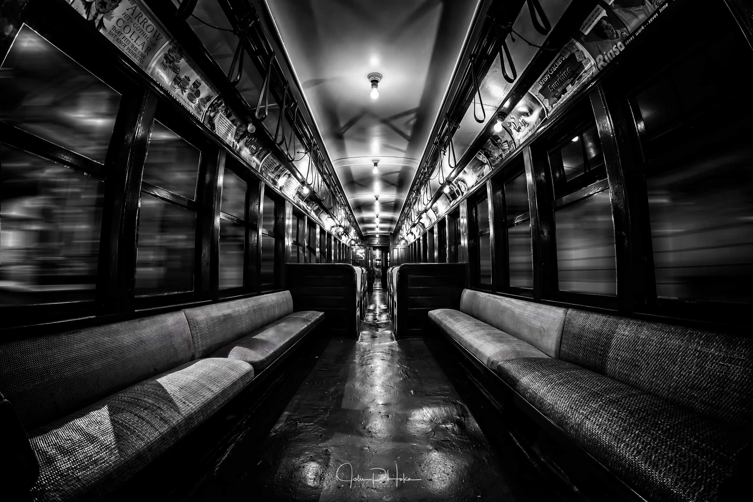 Black and white image of a vintage subway car appearing to move through tunnels at speed. HDR Photo