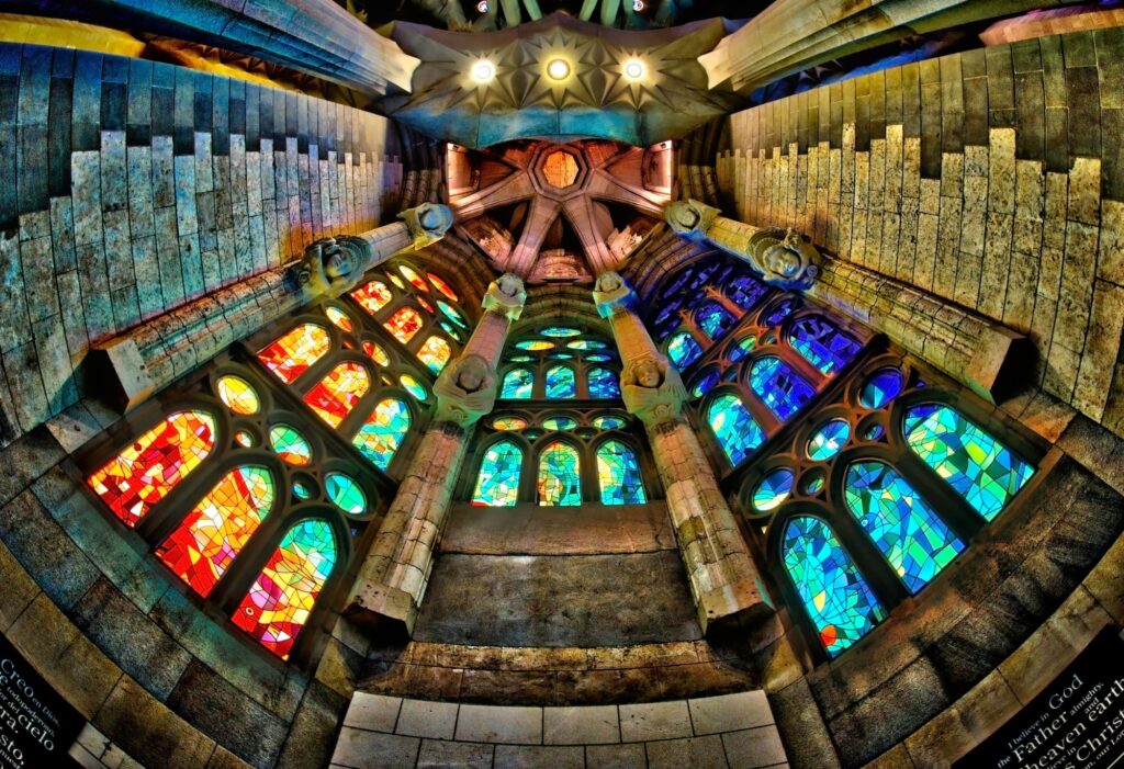 Looking up one of the copses at Sagrada Familia, Barcelona, Spain. HDR image of the lights through the stained glass playing across the church's stonework